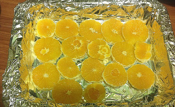 выложить на противень нарезанные апельсины