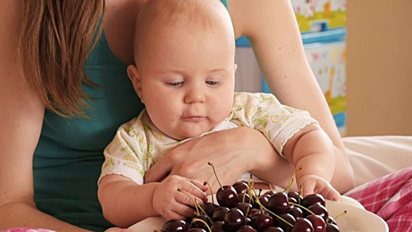 bebê comendo cerejas
