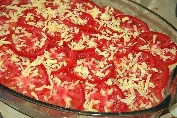 leg een tomaat op een laag en bestrooi met kaas