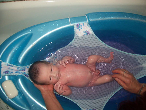 mandi bayi yang baru lahir di tempat tidur buaian