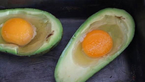 bryte egget i halvdel av avokado